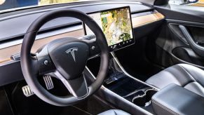 Tesla Model 3 compact full electric car interior with a large touch screen on the dashboard on display at Brussels Expo