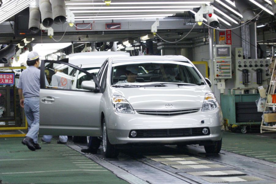 Workers assemble cars at a Toyota production plant