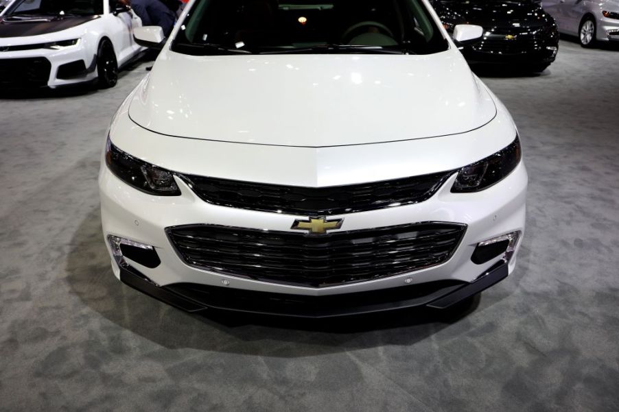 A white Chevy Malibu on display at an auto show