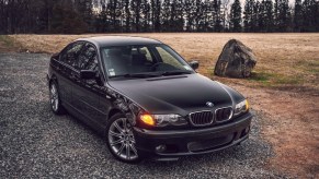 Black 2003 BMW E46 330i ZHP sedan parked on rocky road