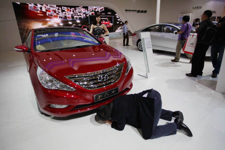 A visitor sees the bottom of a Hyundai Sonata car during the media day of the Shanghai International Automobile Industry Exhibition