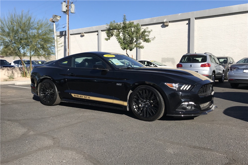 Side view of black-with-gold-stripes 2016 Shelby GT-H Mustang in parking lot