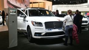 A woman touches the hood of the 2020 Lincoln Navigator L on display at the 2019 Los Angeles Auto Show