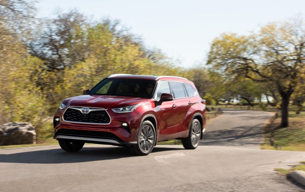 2020 Toyota Highlander Hybrid driving on road in the sun