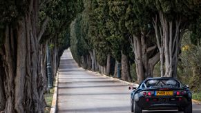 1 1997 Lotus Elise Sport 190 driving on a beautiful country road