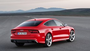 An Audi RS7 Sportback in Misano Red parked in the middle of a road with a mountain backdrop