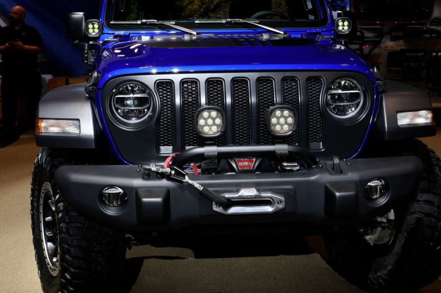 A blue Jeep Wrangler on display at an auto show