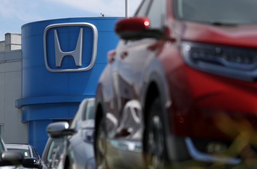 The Honda logo seen in the background of a car dealership