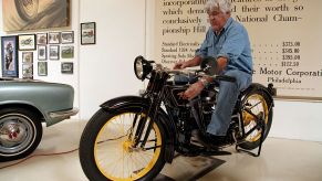 Jay Leno sitting on top of a motorcycle