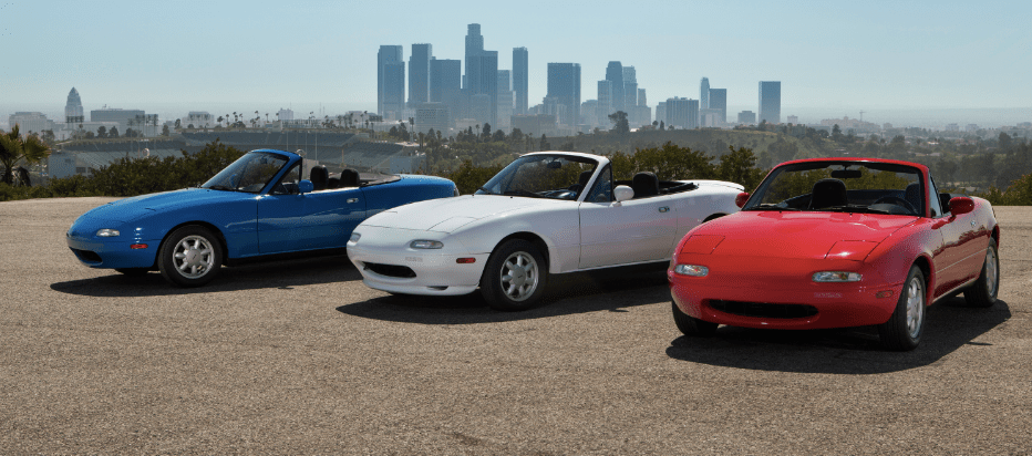 Three Mazda Miatas lines up outside.