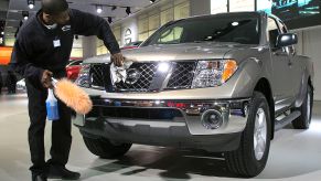 A man polishes the front of a Nissan Frontier