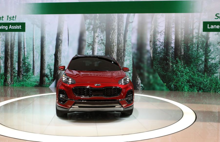 A red Kia Sportage on display at an auto show