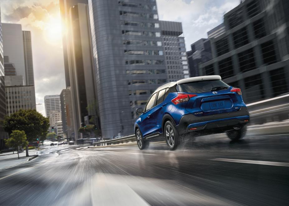 a blue Nissan Kicks navigating city streets