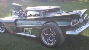 A custom El Camino sits in the grass