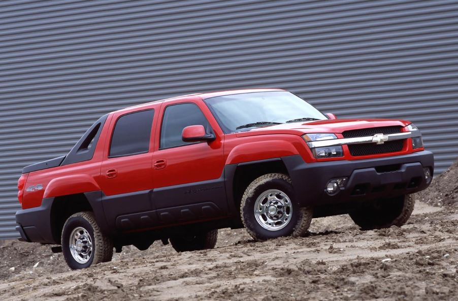 A red 2002 Chevrolet Avalanche sits in front of an industrial building