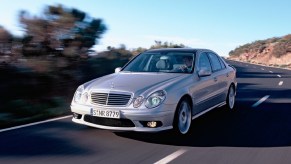 Silver 2003 Mercedes E55 AMG sedan driving down the road