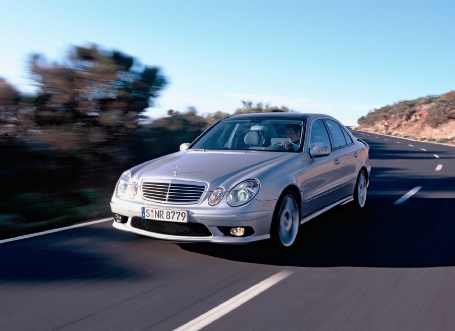 Silver 2003 Mercedes E55 AMG sedan driving down the road