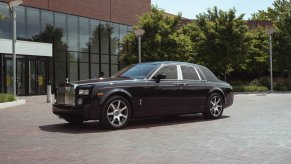 A blue Rolls-Royce Phantom sits in front of office building