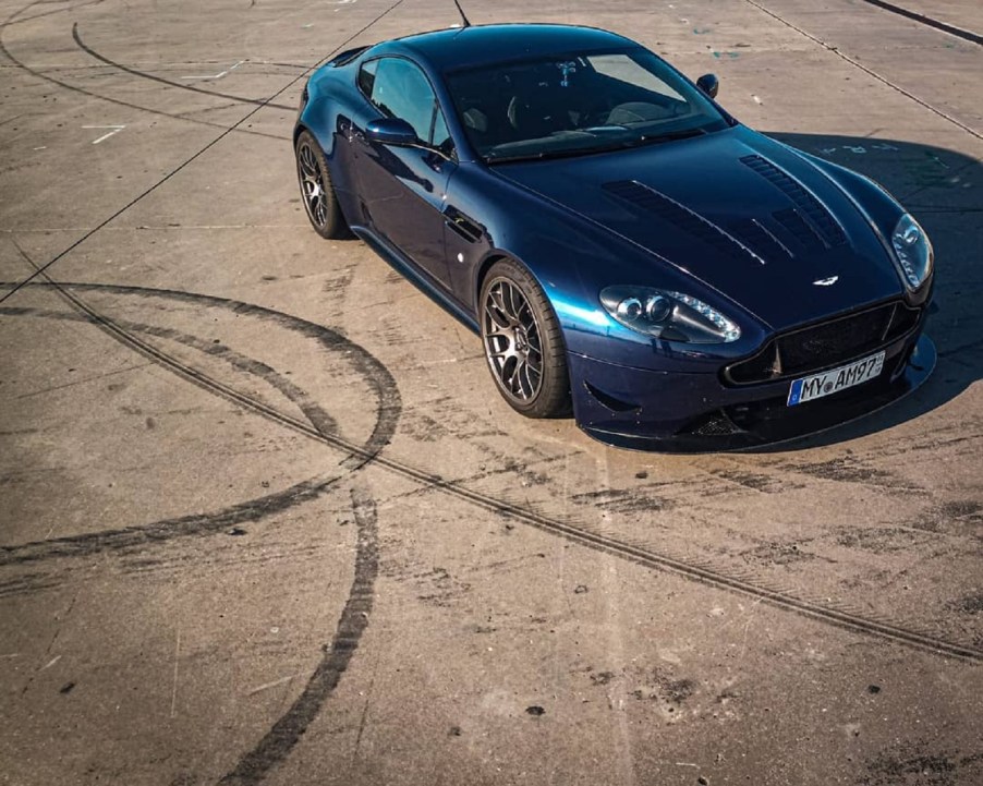 Dark blue 2007 Aston Martin V8 Vantage Valiant restomod on the track