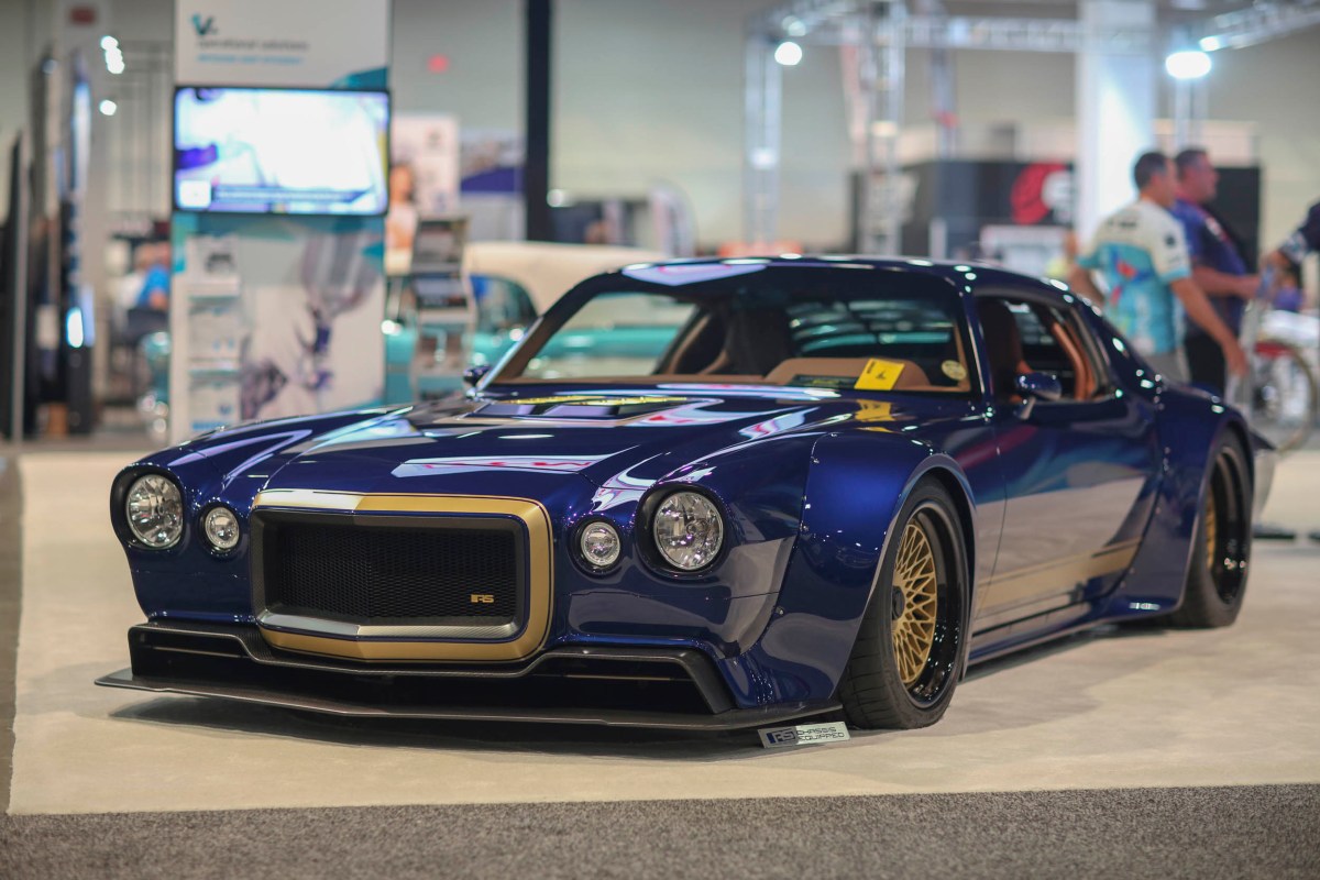 A blue custom Camaro sits on the show floor at the SEMA show