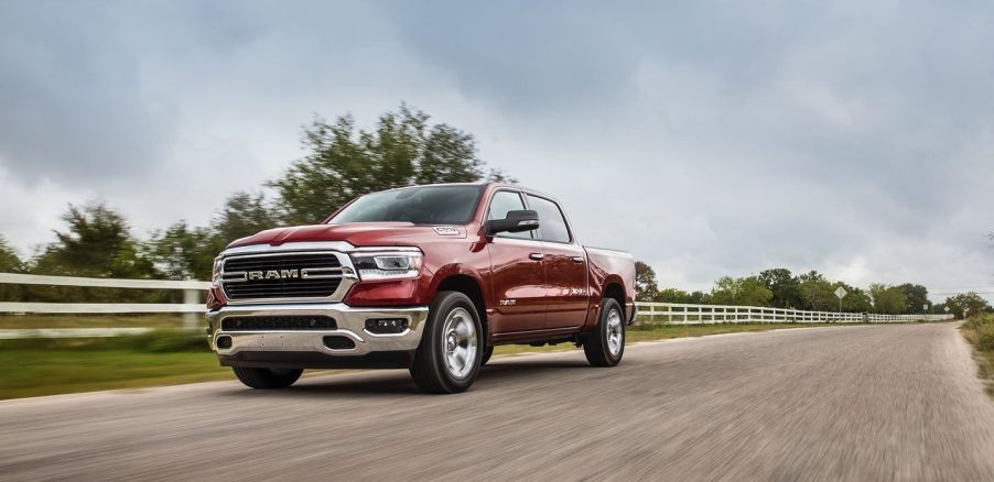 a new red Ram 1500 pickup truck driving through some farm land