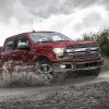 Red 2020 Ford F150 Lariat Super Crew splashes through a stream