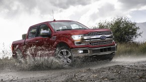 Red 2020 Ford F150 Lariat Super Crew splashes through a stream