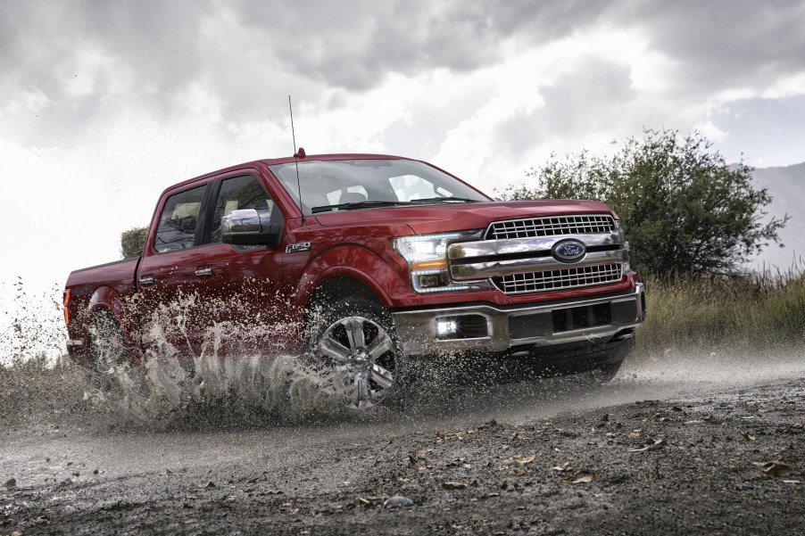 Red 2020 Ford F150 Lariat Super Crew splashes through a stream