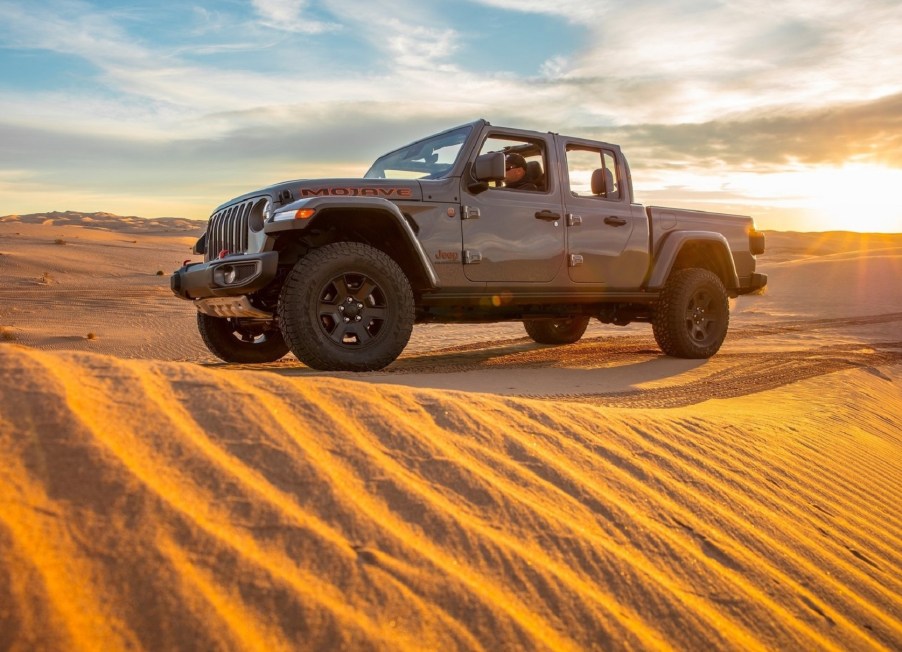 Grey-brown 2020 Jeep Gladiator Mojave truck crossing a dune at sunset