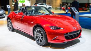 A red Mazda Miata on display at an auto show