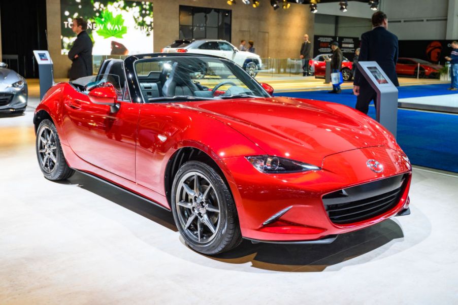 A red Mazda Miata on display at an auto show