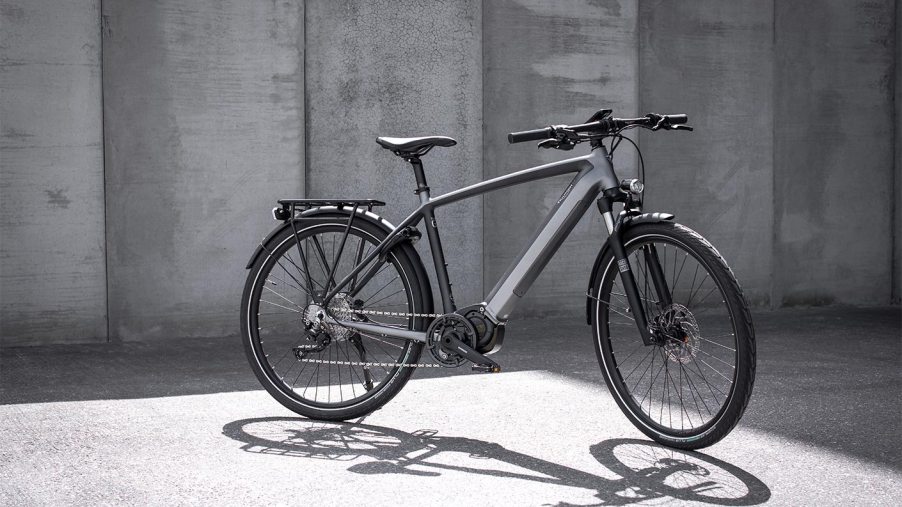 The Triumph E-Trekker GT stands alone before a concrete wall