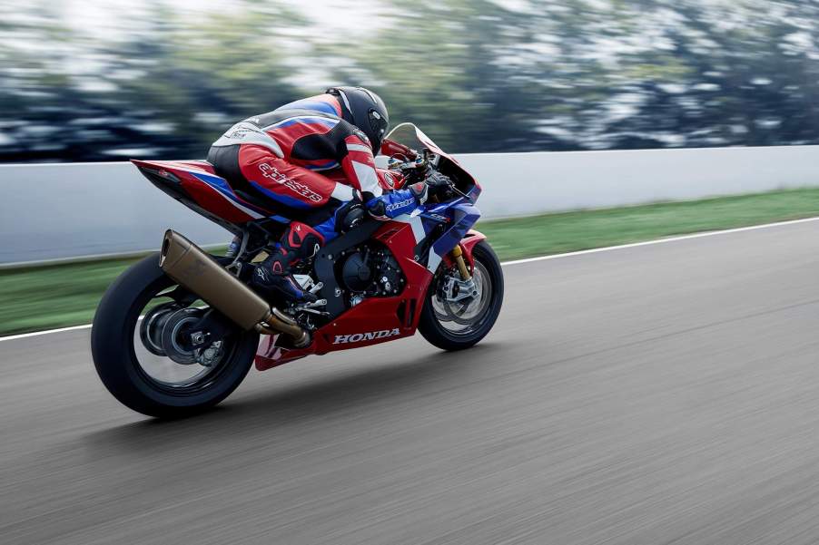 a red, white, and blue CBR1000RR-R sport bike racing down the street