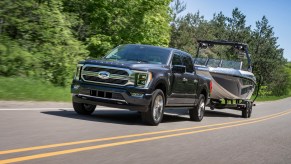 A gray 2021 Ford F-150 Hybrid towing a boat