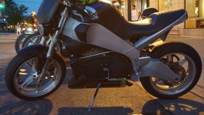 Black-and-silver Buell Lightning with green helmet on a city street