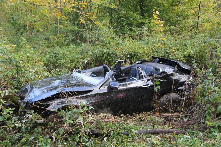 A convertible after a roll-over crash sitting in a field