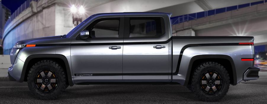 A silver pickup sits in a dark setting.