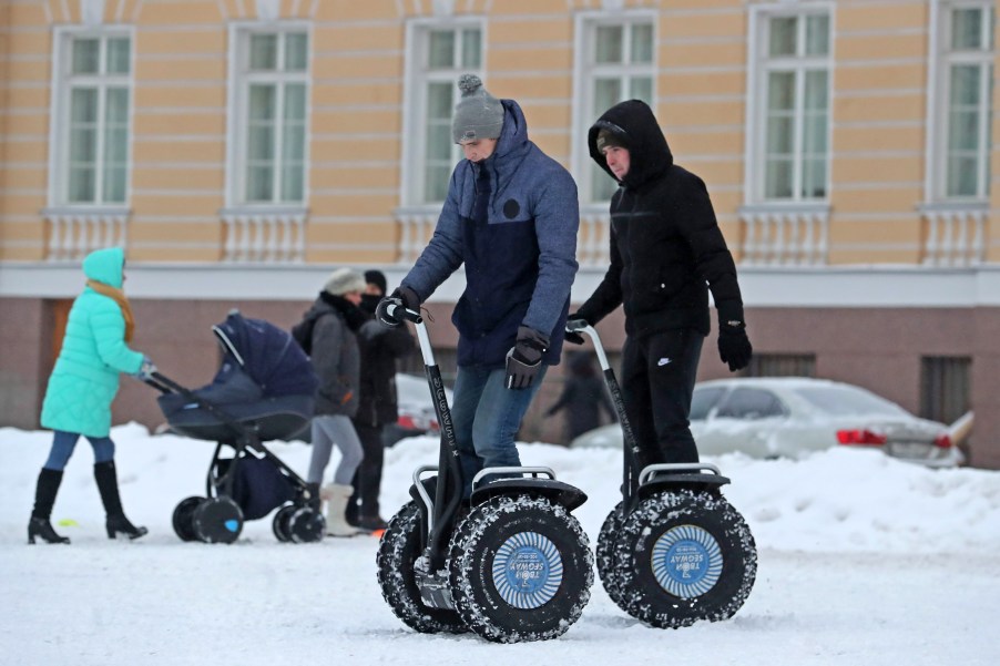 Young men ride Segway two-wheeled personal transporters