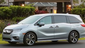 a silver Honda Odyssey parked in front of an upscale residence