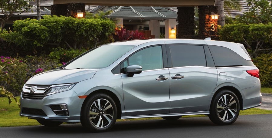 a silver Honda Odyssey parked in front of an upscale residence