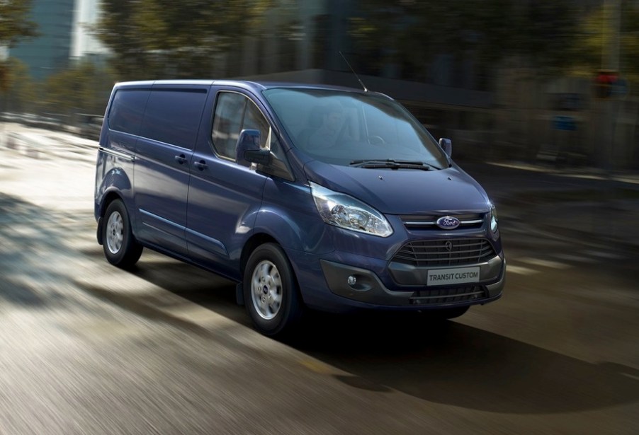 A new blue Ford Transit driving on the street