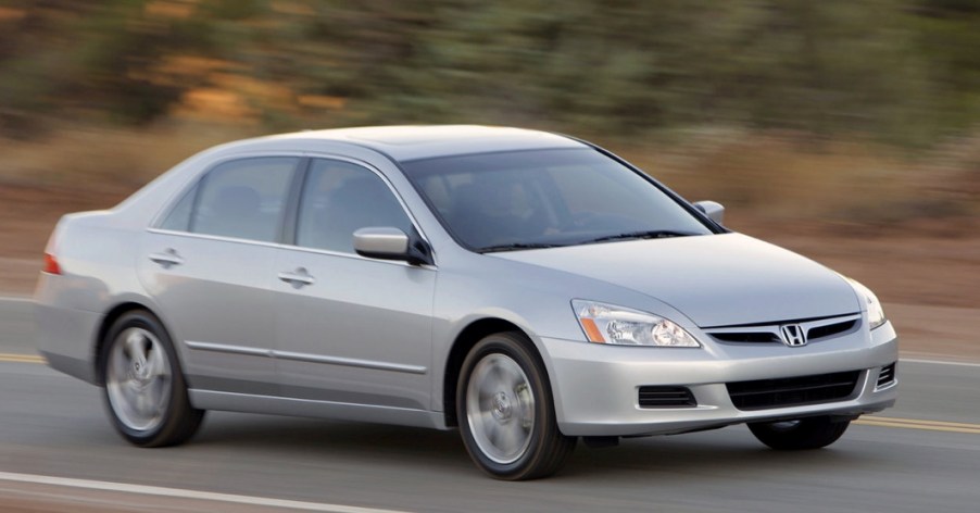 a silver seventh gen Honda Accord driving on a scenic road