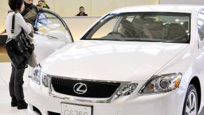 Customers inspects a Lexus car on a showroom floor