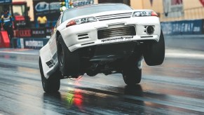 Maatouks Racing's white 2100-hp R32 Nissan Skyline GT-R drag race car pulling a wheelie on the drag strip