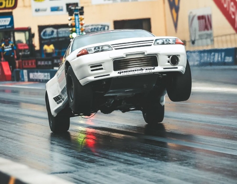 Maatouks Racing's white 2100-hp R32 Nissan Skyline GT-R drag race car pulling a wheelie on the drag strip