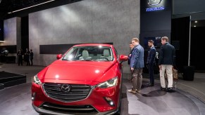 People inspecting a Mazda CX-5 at an auto show