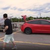 Red Tesla Model 3 with homemade solar panel trailer