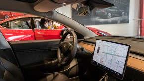 Citizens watch three models of Tesla Model 3, model X and model s in the exhibition hall of the newly opened Tesla experience center