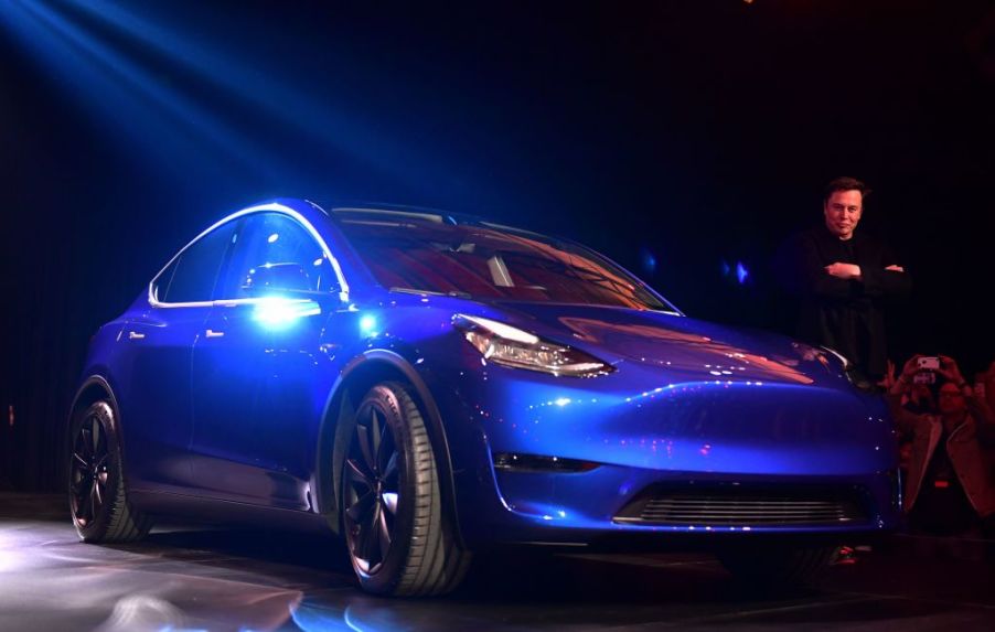 Tesla CEO Elon Musk walks beside the new Tesla Model Y