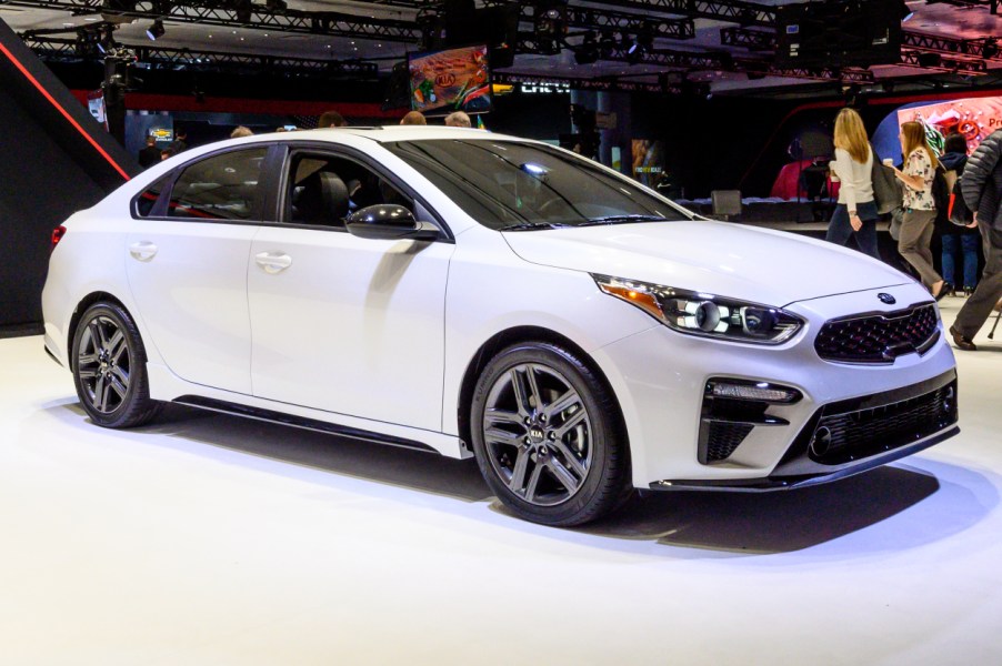 A white Kia Forte on display at an auto show